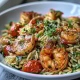 Bright Mediterranean flavors shine in this easy lemon butter shrimp and orzo, featuring zucchini and cherry tomatoes.  