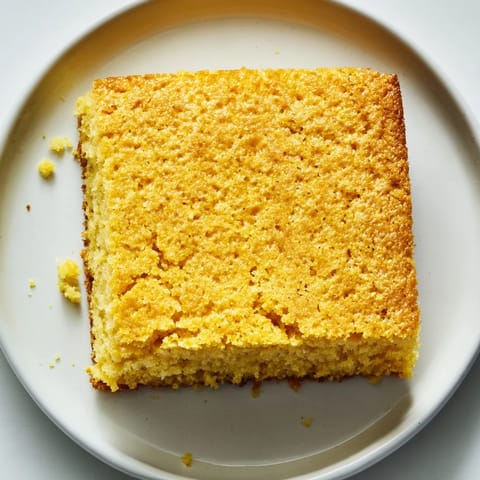 Slices of fluffy Cornbread ready to accompany a steaming bowl of chili for dinner.
