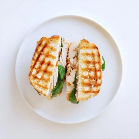 Fresh spinach and juicy grilled chicken layered in a Grilled Chicken Spinach Panini with garlic butter.