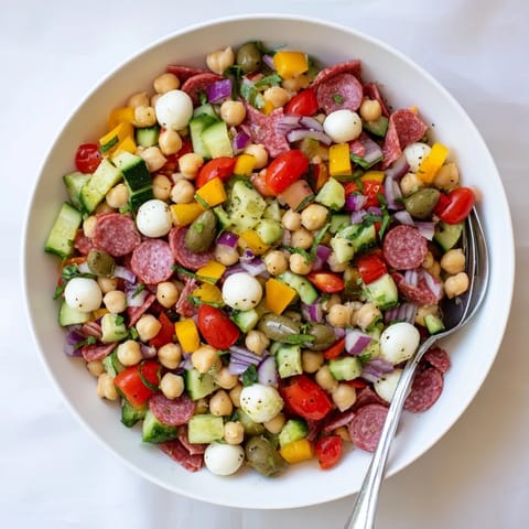 Serving suggestion for Crunchy Antipasto Chopped Salad, plated on a rustic wooden table alongside crusty Italian bread, perfect for a light gluten-free lunch or appetizer.