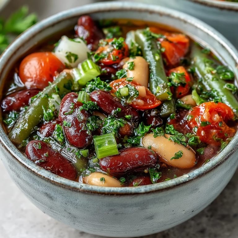 Hearty Three-Bean Salad Soup simmering with colorful vegetables like red onion and celery, ready to be served hot.  
