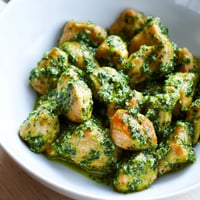 Golden-brown pesto chicken chunks glisten over warm rice, topped with vibrant diced tomatoes and fresh basil leaves in this hearty Chicken Pesto Rice Bowl.  